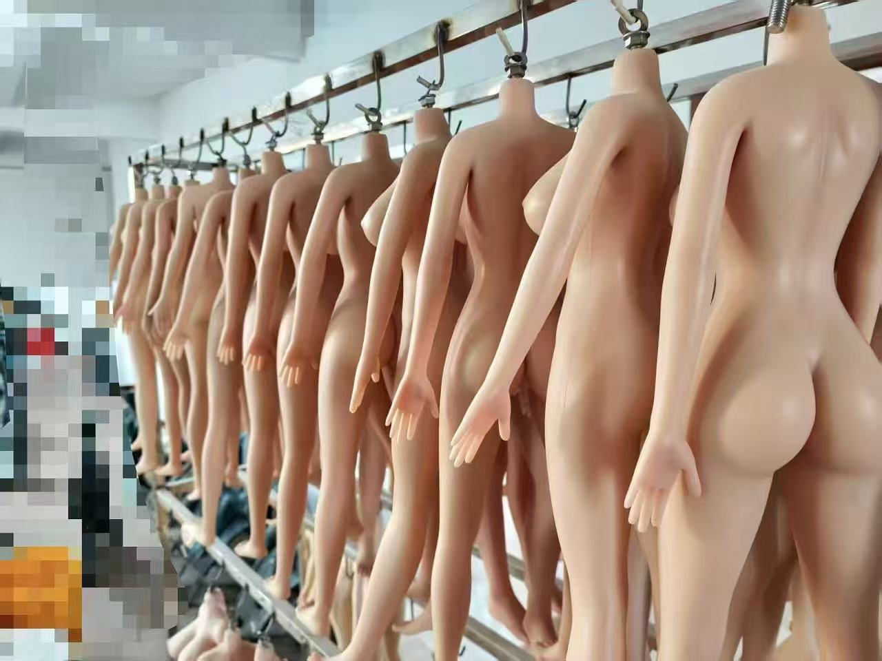 Headless raw silicone bodies hanging from a rail after demolding, back view