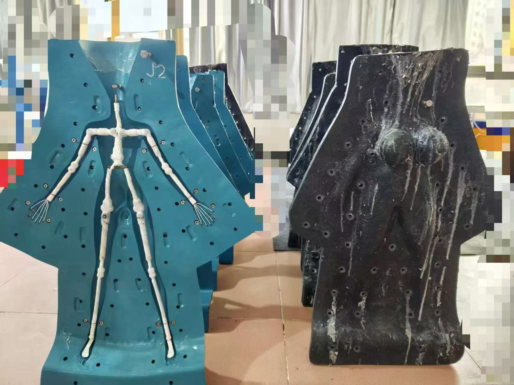 Open body mold with skeleton inside beside closed molds showing silicone drips after pouring