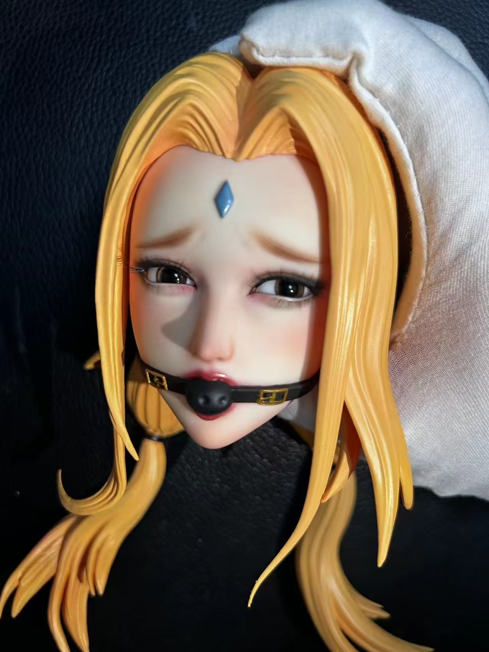 Close-up of a hand-painted Tsunade PU face with blush, lashes and diamond forehead mark